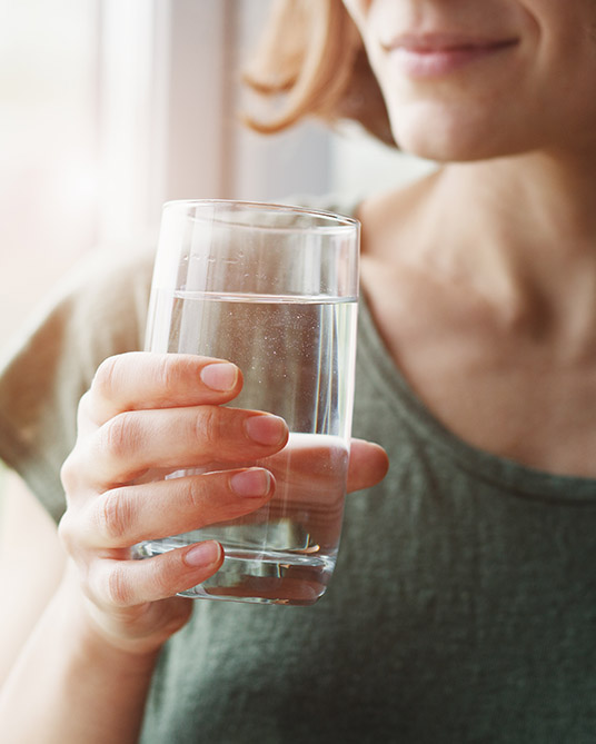 Woman holding a glass of water. 